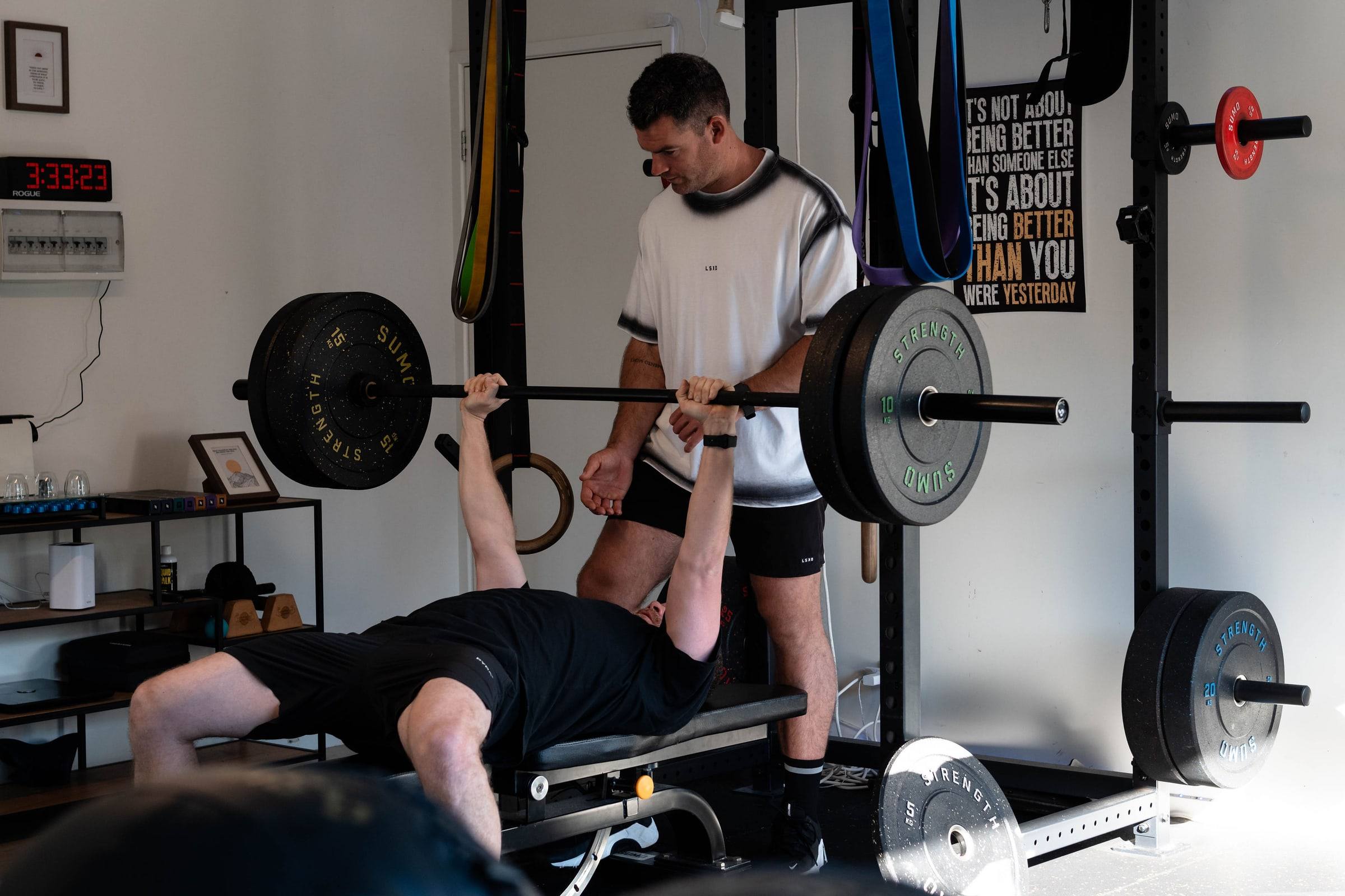 Richy spotting a client on the bench press in the True Fit home gym