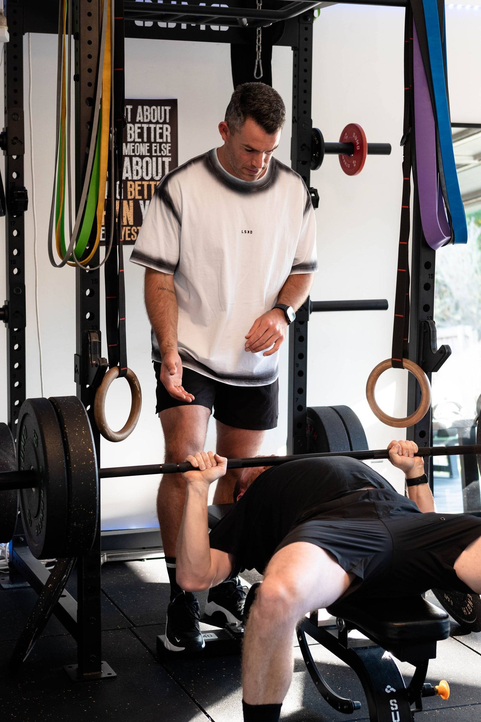 Richy spotting a client on the bench press in the home gym