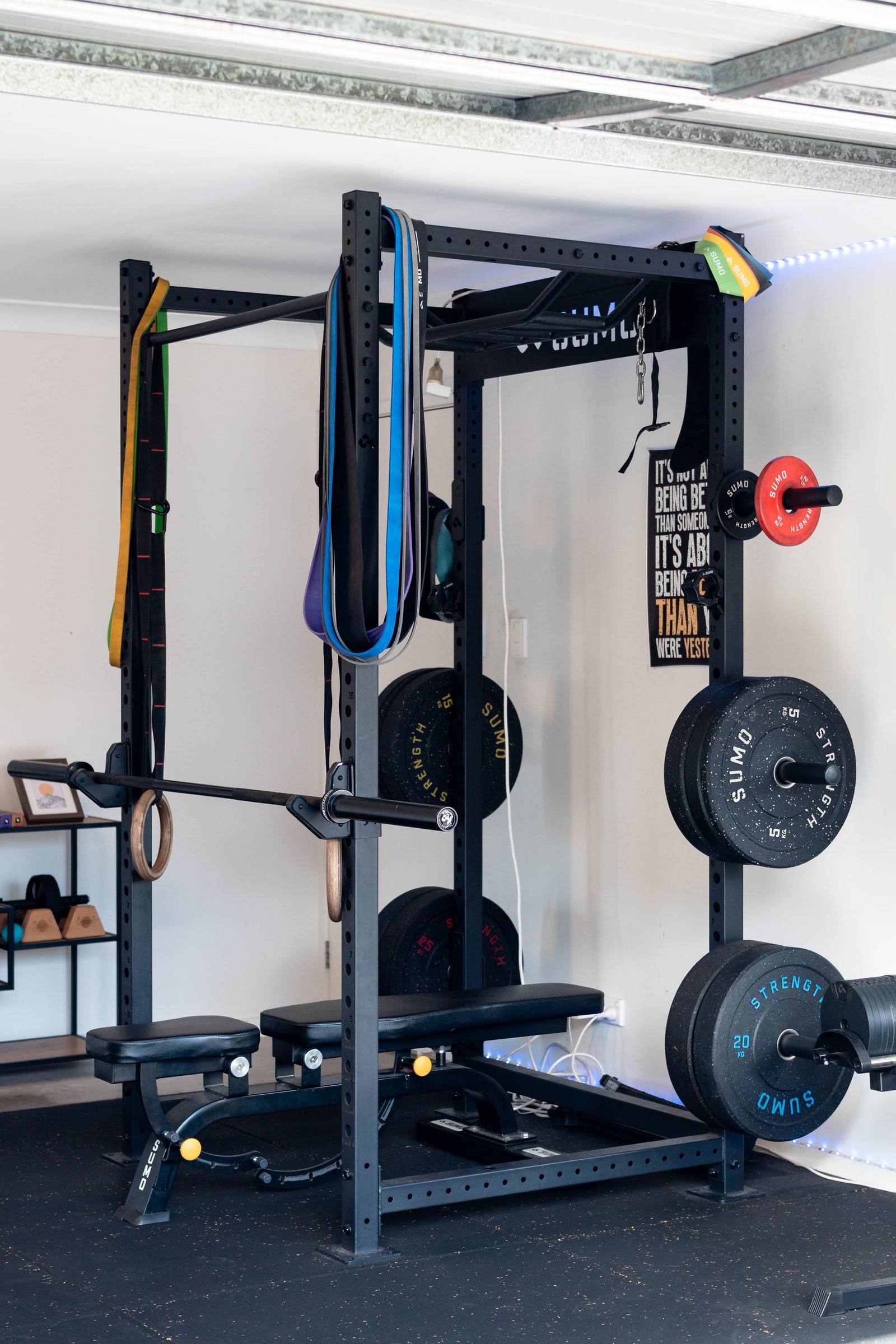 Squat rack with bumper plates, bands and gymnastic rings