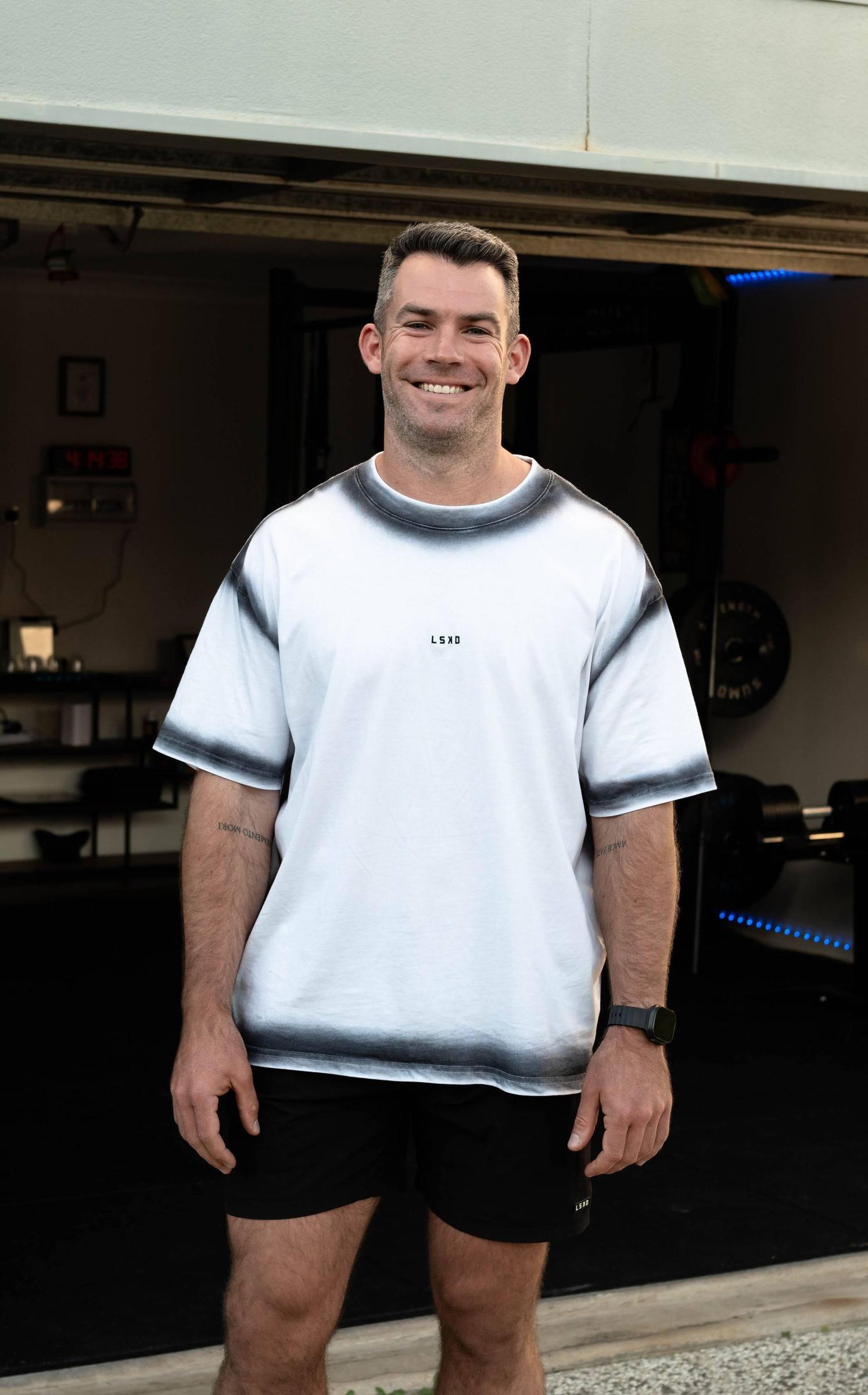 Richy smiling at the open garage door of the True Fit home gym